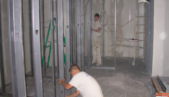 Photo of Standard Drywall employees installing metal stud framing